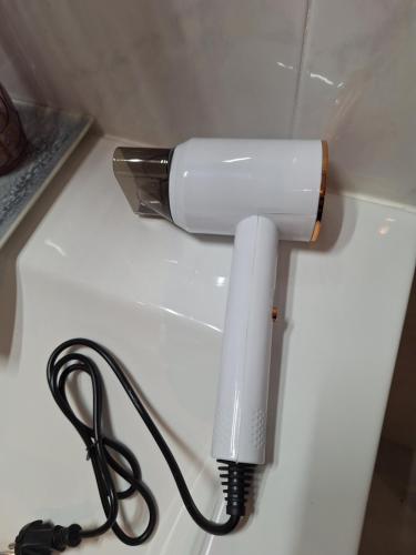 a white blow dryer plugged into a wall at Piso California 3 aire acondicionado, wifi, cerca del mar in Miami Platja