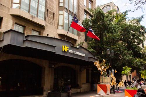 a building with two flags in front of it at Hotel Fundador in Santiago