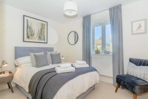 a bedroom with a large bed and a window at Sundowner HM108 Lakeside Spa Property in Somerford Keynes