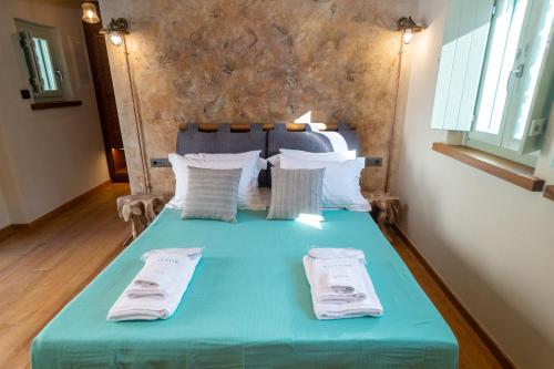 a blue bed with two pillows on it at Nostos Country House in Tsagarada