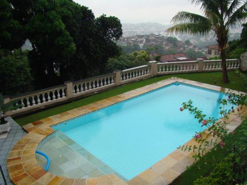 a large blue swimming pool in a yard at Casa das Luzes Hostel IVN in Rio de Janeiro