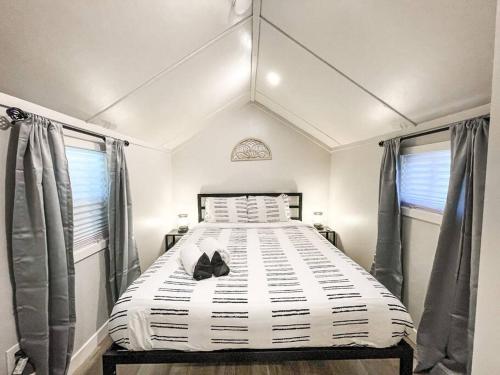 ein Schlafzimmer mit einem großen Bett in einem Zimmer mit Fenstern in der Unterkunft Cozy cottage in the heart of COS - pet friendly in Colorado Springs
