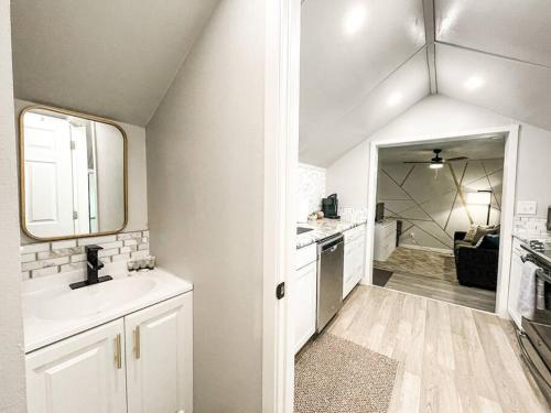 a white bathroom with a sink and a mirror at Cozy cottage in the heart of COS - pet friendly in Colorado Springs