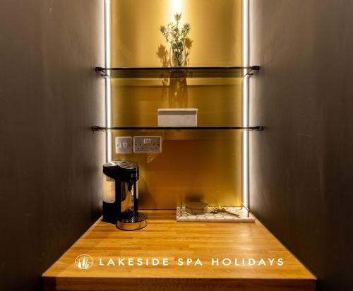 a glass shelf with a coffee maker in a room at Reflections HM77 HOT TUB Lakeside Spa NEW in Somerford Keynes