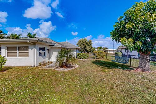 a house with a tree in the yard at A Sunshine State of Mind in North River Shores