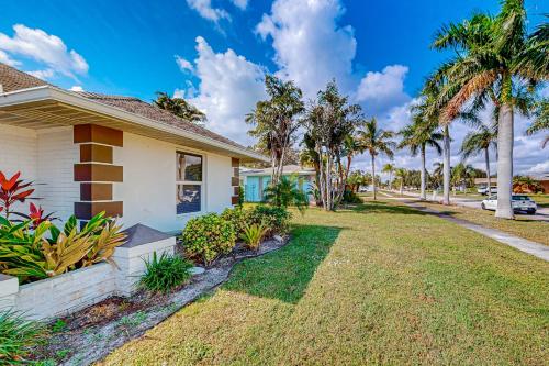 a house with a yard with palm trees at A Sunshine State of Mind in North River Shores