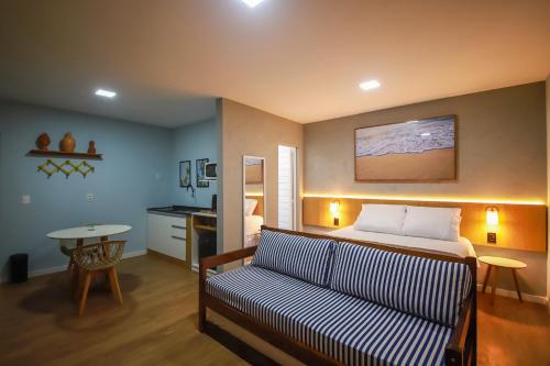 a bedroom with a bed and a couch and a table at O Azul de Maragogi - Pousada Premium in Maragogi