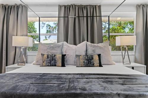 Un dormitorio con una cama grande con dos lámparas. en Luxury pool home near the beach!, en Seminole