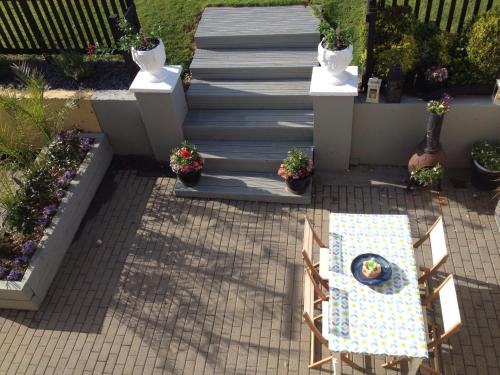 a patio with a table and stairs with plants at The Well Bed & Breakfast in Clonakilty