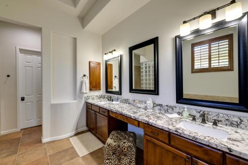 a bathroom with two sinks and two mirrors at Spacious North Phoenix Oasis with Pool and Patio! in Phoenix
