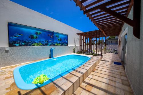 an indoor swimming pool with an aquarium on the wall at O Azul de Maragogi - Pousada Premium in Maragogi