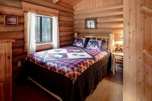 a bedroom with a bed in a log cabin at Experience Montana Cabins - Bear's Den #4 in Bigfork