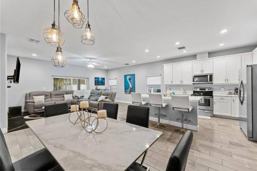 a kitchen and living room with a table and chairs at Modern Pool Home w Putting Green in Largo