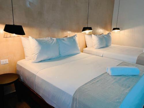 two beds in a hotel room with white pillows at Arena Apartment 2 in Holbox Island