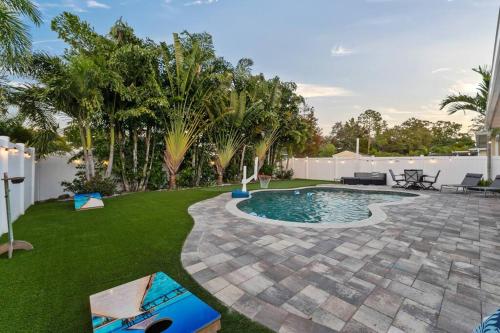 a backyard with a swimming pool and green grass at Modern Pool Home w Putting Green in Largo