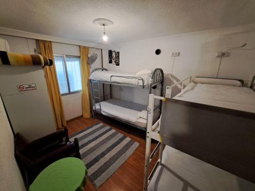 Kleines Zimmer mit 2 Etagenbetten und einem TV. in der Unterkunft El Cascabel in Granada