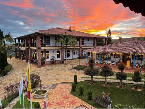 un bâtiment avec drapeaux devant lui et coucher de soleil dans l'établissement Kimbala Resort, à Curití