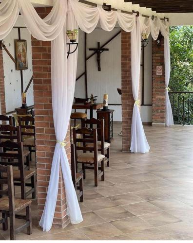 クリティにあるKimbala Resortの白いカーテン、テーブル、椅子が備わる客室です。