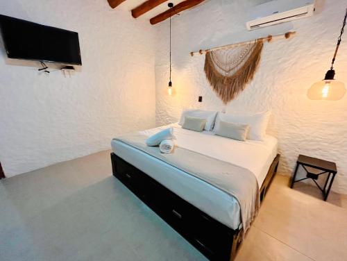 a bedroom with a bed with a tv on the wall at Casa Arena Holbox! in Holbox Island