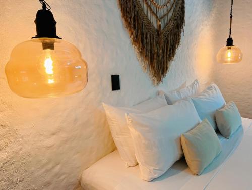 a room with a white couch with pillows and lights at Casa Arena Holbox! in Holbox Island