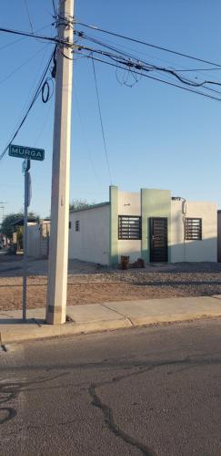 een paal met een straatbord naast een gebouw bij Confortable habitación in Colonia Alamitos