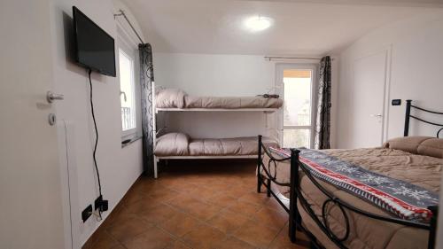 1 dormitorio con 2 camas y TV de pantalla plana en La Petite Maison Coazze, en Coazze