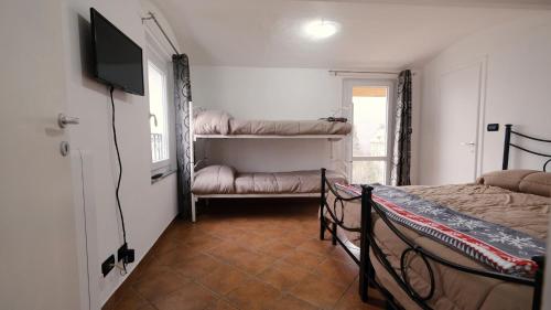 ein Schlafzimmer mit zwei Betten und einem Flachbildfernseher in der Unterkunft La Petite Maison Coazze in Coazze