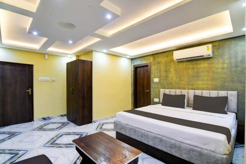 um quarto com uma cama e uma mesa num quarto em The Crown em Calcutá