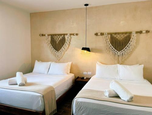 two beds sitting next to each other in a room at Arena Apartment 1 in Holbox Island