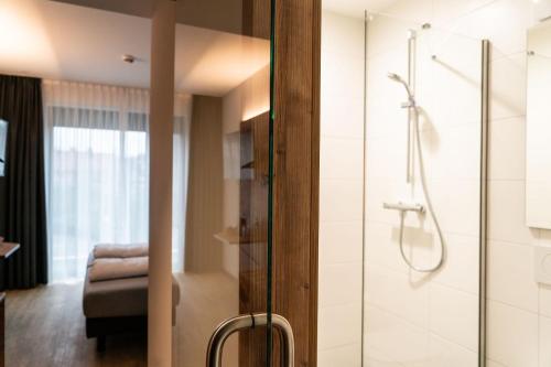 a bathroom with a shower with a glass door at SEKRA Stadthotel 