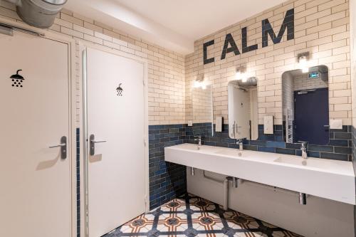 a bathroom with two sinks and two mirrors at CALM Appart' & Hostel in Lille