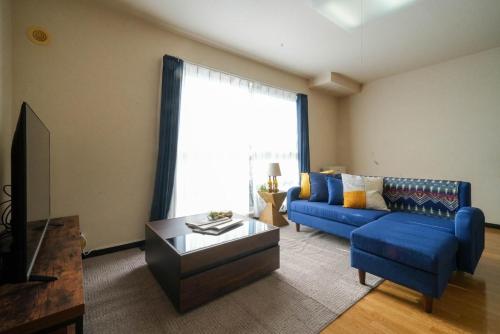a living room with a blue couch and a table at Riverside mansion - Vacation STAY 15861 in Shinhidaka