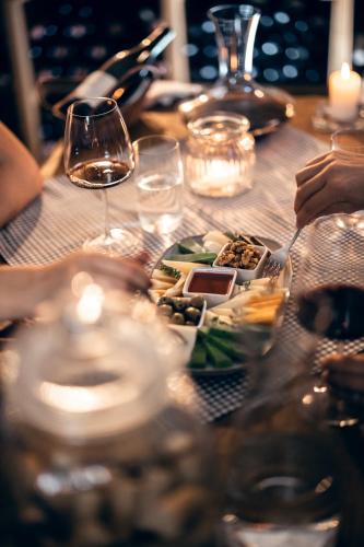 a table with a plate of food and glasses of wine at Apartmány nad stájemi - Jítravský Dvorec in Rynoltice