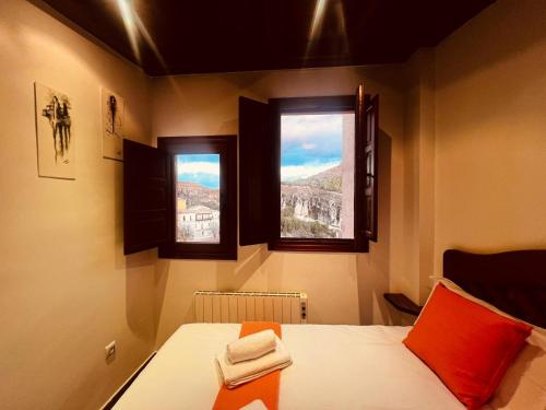 a room with a bed and two windows in it at Rascacielos San Martín in Cuenca