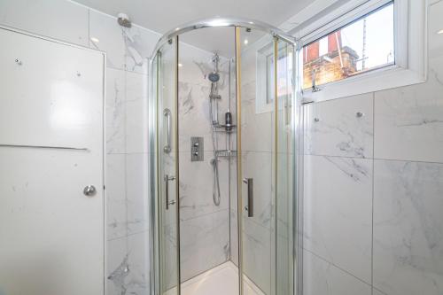 a shower with a glass door in a bathroom at Ultra Central London, Modern Flat in Leafy Street in London