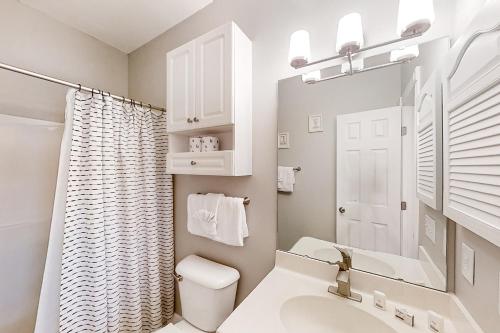 a bathroom with a sink and a toilet and a mirror at Cypress Bay 14-204 in Little River