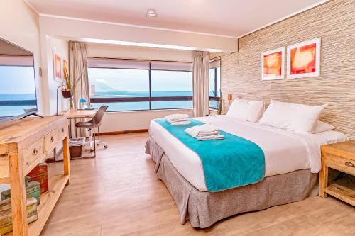 a bedroom with a large bed with a desk and a desk at Hotel Gavina Costa Mar in Iquique