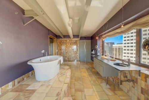 a large bathroom with a tub and a large window at 1600 KCM Penthouse Apartment in Cleveland