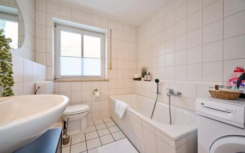 La salle de bains est pourvue d'une baignoire, de toilettes et d'un lavabo. dans l'établissement apanoxa homes I zentral I Parkplätze I Deluxe Apartment, à Straubing