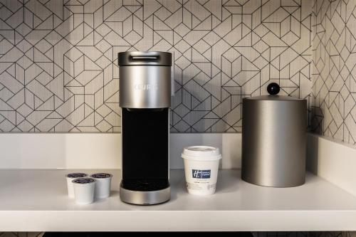 a coffeemaker sitting on a counter next to two cups at Holiday Inn Express Toronto-North York by IHG in Toronto