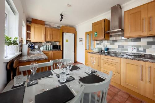 uma cozinha com uma mesa com copos de vinho em “TAWAW” A Lux 2BD Bungalow Harton South Shield em South Shields