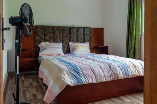 een slaapkamer met een bed en een ventilator bij E&T Resorts in Buea