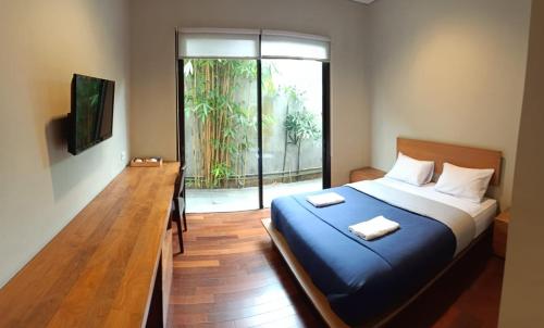a bedroom with a bed and a sliding glass door at The Heritage Karawaci in Binong