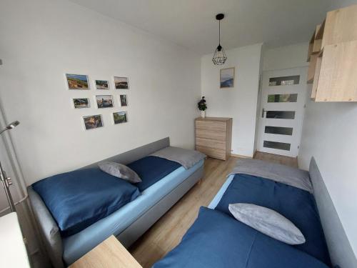dwa łóżka w sypialni z niebieską pościelą w obiekcie Odpocznij w Lesku w mieście Lesko