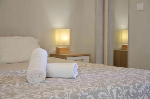 a bedroom with a bed with two rolled towels on it at Ria Terrace Apartment III in Faro