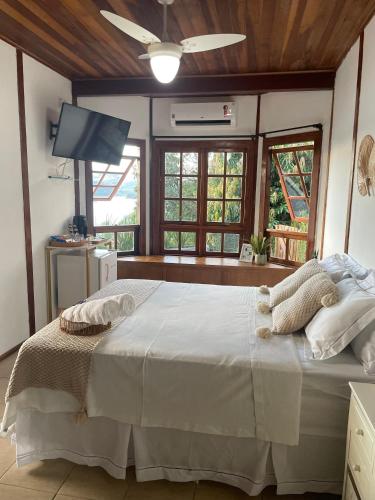 a bedroom with a large bed with a ceiling fan at Chalé das Águas in Igaratá