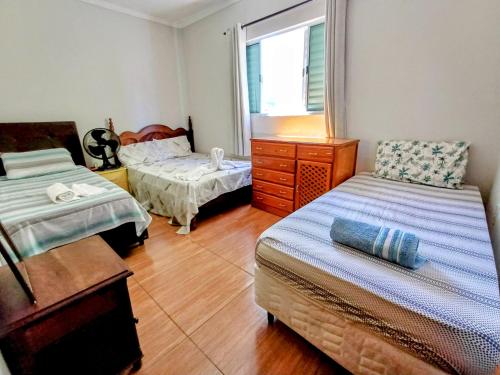 1 dormitorio con 2 camas, vestidor y ventana en Básico e Aconchegante en Itajubá