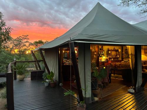 a tent on a deck with plants on it at Out in Africa Wildlife Lodge in Dinokeng Game Reserve