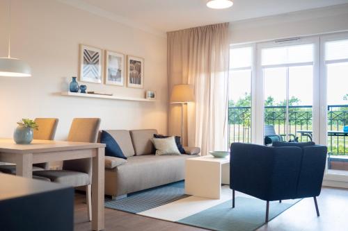 un soggiorno con divano e tavolo di Aparthotel Waterkant Suites - Fewos am Meer mit SPA a Börgerende-Rethwisch