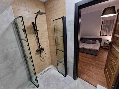 a bathroom with a shower and a bed in a room at Przy Ostrewkach Małe Ciche in Murzasichle